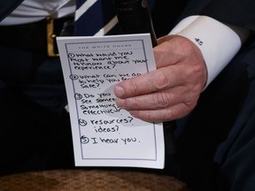 President Donald Trump holds notes during a listening session with high school students and teachers in the State Dining Room of the White House in Washington, Wednesday, Feb. 21, 2018. Trump heard the stories of students and parents affected by school shootings, following last week's deadly shooting in Florida.