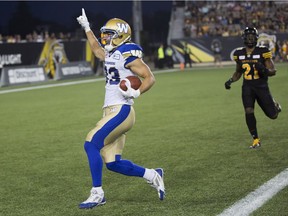 Winnipeg Blue Bombers receiver Julian Feoli-Gudino, left, crosses the goal line to score a touchdown against the Hamilton Tiger-Cats in first-half CFL action in Hamilton, Ont., Saturday, August 12, 2017.