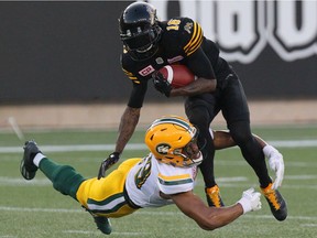 Andrew Lue, then with the Eskimos, tackles Tiger-Cats kick returner Brandon Banks during a game last July. Lue signed with the Redblacks as a free agent on Thursday.