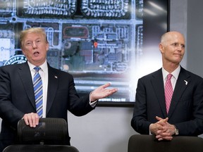 President Donald Trump, left, accompanied by Florida Gov. Rick Scott, right, speaks as they meet with law enforcement officers at Broward County Sheriff's Office in Pompano Beach, Fla., Friday, Feb. 16, 2018, following Wednesday's shooting at Marjory Stoneman Douglas High School, in Parkland, Fla.