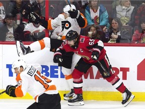 Senators defenceman Erik Karlsson sends Flyers centre Travis Konecny into the boards during an Oct. 26 game in Ottawa. The Senators won that night, 5-4.