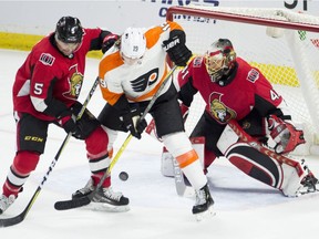 Ottawa Senators goaltender Craig Anderson keeps his eye on the puck as the Philadelphia Flyers' Nolan Patrick tries to deflect a shot while under pressure from defenceman Cody Ceci during the first period at the CTC on Saturday, Feb. 24, 2018.