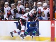 Senators winger Alex Burrows, left, checks the Canucks' Troy Stecher through an open door at the bench during a game at Vancouver on Oct. 10.