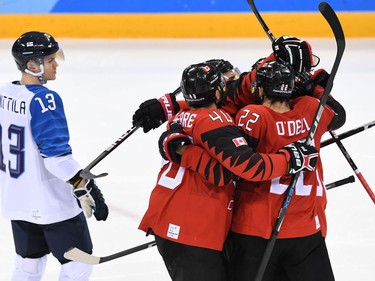 Canadian players celebrate Maxim Noreau's goal against Finland on Feb. 21.