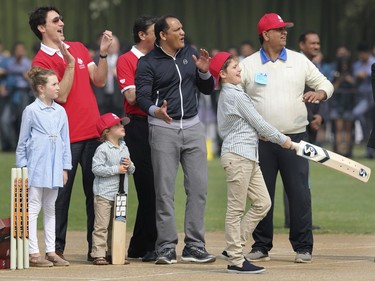 Canadian Prime Minister Justin Trudeau, second left, with his son Hadrien, daughter Ella-Grace, second left, and former Indian cricket team captain Mohammad Azharuddin, center, clap after prime minister's son Xavier hits a ball while trying his hand in cricket in New Delhi, India, Thursday, Feb. 22, 2018.