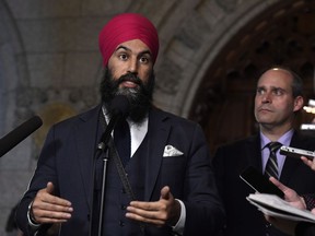 NDP Leader Jagmeet Singh answers a question during an availability following a meeting of the NDP caucus, as MP Guy Caron looks on, on Parliament Hill in Ottawa on Wednesday, Feb. 7, 2018. Singh says he is considering whether his party should push to abolish the use of so-called peremptory challenges in the jury selection process.