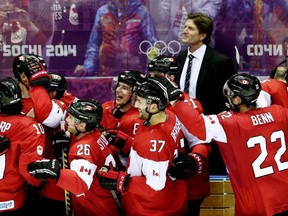 Team Canada head coach Mike Babcock smiles as the squad celebrates winning gold in men's hockey at the 2014 Sochi Winter Olympics in Sochi, Russia, on Feb. 23, 2014.