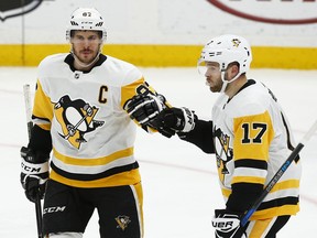 Pittsburgh Penguins' Sidney Crosby, left, is congratulated by Bryan Rust after scoring a goal during the third period of an NHL hockey game against the St. Louis Blues Sunday, Feb. 11, 2018, in St. Louis. The Penguins won 4-1.