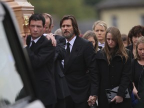 FILE- In this Oct. 10, 2015, file photo, actor Jim Carrey, center, joins mourners behind the coffin of his ex-girlfriend Cathriona White as they walk to Our Lady of Fatima Church, in her home village of Cappawhite, Co Tipperary, Ireland, ahead of her funeral. A wrongful death lawsuit filed by the husband and mother of White was dismissed on Jan. 25, 2018. Mark Burton and Brigid Sweetman sued Carrey claiming he provided the prescription drugs White used to overdose in September 2015. Coroner's officials ruled White's death a suicide.