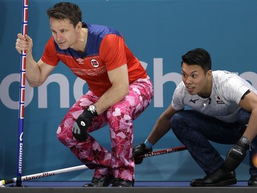 Norwegian skip Thomas Ulsrud, left, and Japan's Tsuyoshi Yamaguchi look at stone placements during Wednesday's match in Gangneung.