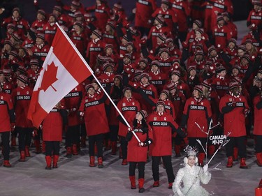 Tessa Virtue and Scott Moir carries the flag of Canada during the opening ceremony of the 2018 Winter Olympics in Pyeongchang, South Korea, Friday, Feb. 9, 2018.