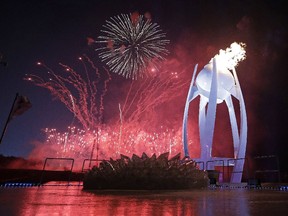 Fireworks explode behind the Olympic flame during the opening ceremony of the 2018 Winter Olympics in Pyeongchang, South Korea, Friday, Feb. 9, 2018.