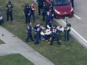 In this frame grab from video provided by WPLG-TV, emergency personnel wheel an injured person from the Marjory Stoneman Douglas High School in Parkland, Fla., following a shooting there on Wednesday, Feb. 14, 2018.