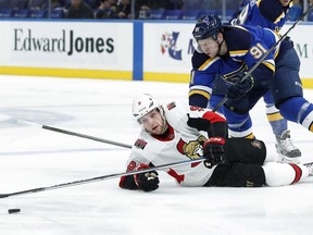 Ottawa Senators' Bobby Ryan, bottom, reaches for a puck after being knocked to the ice by St. Louis Blues' Vladimir Tarasenko, of Russia, during the first period of an NHL hockey game Tuesday, Jan. 23, 2018, in St. Louis.