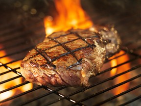 barbecue beef steak cooking over flaming grill, shot with selective focus