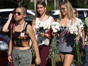 Emma Gonzalez (L), a senior at Marjory Stoneman Douglas High School, and others return to the school on February 25, 2018, for the first time since the shooting that killed 17 people on February 14 in Parkland, Florida.