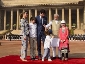 Indian Prime Minister Narendra Modi covers Hadrien's face with his hat as Prime Minister Justin Trudeau wife Sophie Gregoire Trudeau, and children, Xavier, 10, Ella-Grace, take part in the official welcoming ceremony in New Delhi, India on Feb. 23.