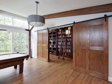 Sliding barn doors separate the library from the family room and can create a 'secret getaway' for the homeowner's young daughters, who are 10 and 12 years old.