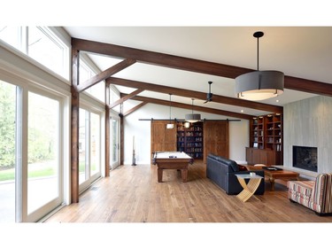 Wooden accents on the addition's sliding barn doors, beams and cabinetry give a warm feeling to a transitional family space.