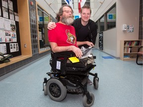 John Woodhouse has a new wheelchair to help him 
get around town. A neighbourhood friend and JCC gym manager Ryan Armitage, above, helped make it happen.
