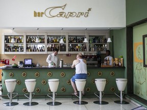 FILE - In this Sept. 12, 2017, file photo, a customer sits at the lobby bar of the Hotel Capri in Havana, Cuba. Doctors are releasing the first detailed medical reports about the hearing, vision, balance and brain symptoms suffered in what the State Department has called "health attacks" on U.S. diplomats in Cuba. Still missing: A clear diagnosis of just what happened to trigger their mysterious health problems.