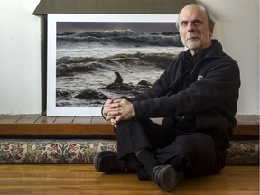 Photographer J.A. Lamont in front of one of his photographs taken in northern B.C. during a 2015 hurricane.