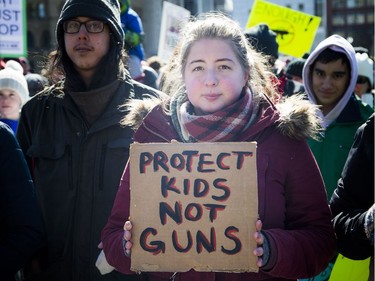 March For Our Lives Ottawa started on Parliament Hill Saturday March 24, 2018, making its way over to Major's Hill Park. People of Ottawa took to the streets joining with others all over North America to demand lives and safety become a priority and to end gun violence and mass shootings in schools. Lisa Maranta stands on Parliament Hill with a Protect Kids Not Guns sign.   Ashley Fraser/Postmedia