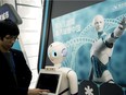 An iFlyTek robot that uses artificial intelligence is shown in Beijing. How do we en sure the world uses AI responsibly?