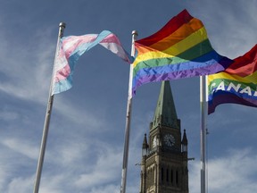The pride and transgender flags fly on Parliament Hill following a ceremony with Prime Minister Justin Trudeau in Ottawa, Wednesday June 14, 2017.