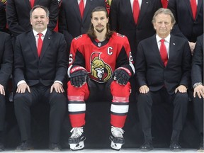 Senators captain Erik Karlsson is flanked by general manager Pierre Dorion and owner Eugene Melnyk in the front row of the team photo taken Wednesday at Canadian Tire Centre.