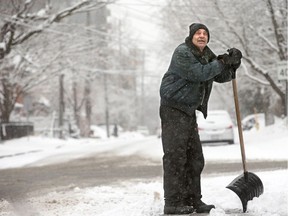 A man in the Glebe takes a breather from shovelling.