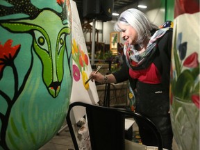 Local artist Jill Alexander paints blooms in between giant tulips at the Home and Garden Show's tulip area Thursday. Alexander has painted seven of the Canadian Tulip Festival's large tulips since 2002. The festival runs this year May 11-21.