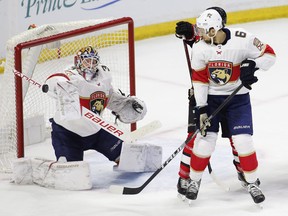 Florida Panthers goaltender James Reimer stops the puck as defenceman Alexander Petrovic and Senators winger Tom Pyatt look on during Thursday's game. (THE CANADIAN PRESS)