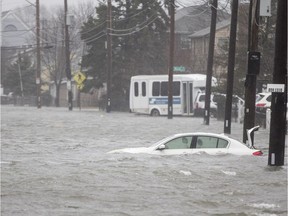 A car sits submerged due to a strong coastal storm.