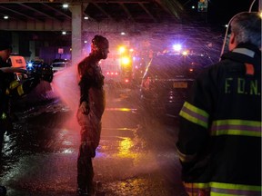 A FDNY diver is sprayed with water after attending a call of a helicopter crashed in the East River on March 11, 2018 in New York City.