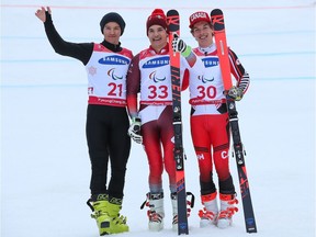 Gatineau's Alexis Guimond, right, stands beside silver medallist Aleksei Bugaev, left, of Neutral Paralympic Athlete and gold medallist Theo Gmur of Switzerland at the victory ceremony for the men's standing giant slalom event on Wednesday.