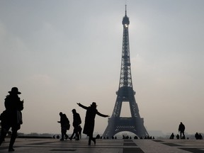 TOPSHOT - The silhouette of a woman is seen as she poses next to the Eiffel Tower in Paris on February 21, 2018.