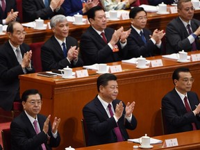 Chinese President Xi Jinping (centre), Premier Li Keqiang (right) and National People's Congress Chairman Zheng Dejiang (left) applaud during the opening session of the National People's Congress, China's legislature, in Beijing's Great Hall of the People on March 5, 2018.