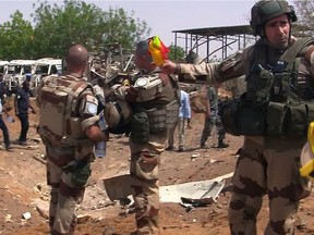 (FILES) This file photo taken on June 1, 2016 shows United Nations (UN) peacekeepers soldiers standing in front of Chinese UN peacekeeping forces camp in Gao after Al-Qaeda's North African affiliate AQIM claimed responsibility for May 31 attacks that killed Chinese peacekeeper and three civilians working for the UN's Mali mission the US monitoring SITE said. Canada has told the United Nations it is willing to join the peacekeeping mission in Mali, and will send peacekeepers backed by helicopters, a government source said on Marcg 16, 2018.