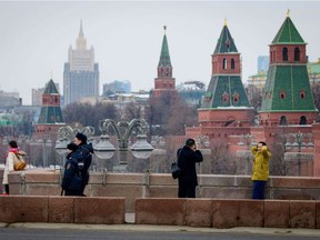 A pair of police officials patrol among sightseers on a bridge outside The Kremlin in Moscow on March 26, 2018. The Kremlin has insisted that Moscow is innocent in the poisoning of former Russian spy Sergei Skripal after the US, Canada and several EU countries expelled Russian diplomats over the case.