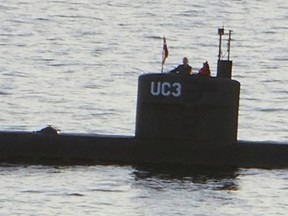 A woman alleged to be Swedish journalist Kim Wall stands next to a man alleged to be Peter Madsen in the tower of the private submarine "UC3 Nautilus" on August 10, 2017 in Copenhagen Harbour.