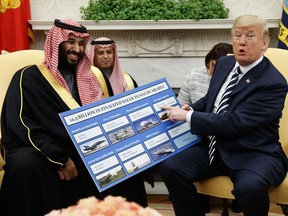 President Donald Trump shows a chart highlighting arms sales to Saudi Arabia during a meeting with Saudi Crown Prince Mohammed bin Salman in the Oval Office at the White House, Tuesday, March 20, 2018.