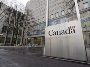 A Government of Canada sign sits in front of a Library and Archives Canada building next to Parliament Hill in Ottawa.