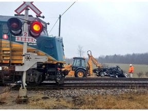 Crews clean up after a fugitive car was sideswiped by a Via Rail train after it was abandoned at the side of tracks near Bath, Ont. There were no injuries, five men have been arrested.