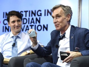 Bill Nye shows off a Canadian $5 bill, which features an astronaut and the Canadarm as Prime Minister Justin Trudeau looks on during an armchair discussion highlighting Budget 2018's investments in Canadian innovation at the University of Ottawa in Ottawa on Tuesday, March 6, 2018.