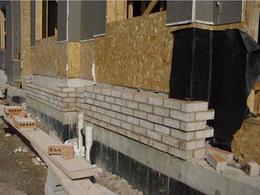 This typical Canadian brick veneer installation combines the advantages of masonry with the ease of wood frame construction. These bricks will continue up past the windows and right to the underside of the roof.