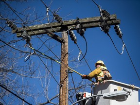 Jeremy Gilbert works to repair a power line after a storm passed through the area on Saturday.