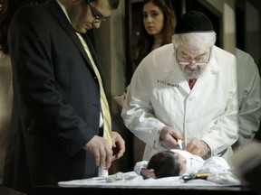 A campaign to ban circumcision for infants and children has taken hold in Iceland and Denmark but is far too radical a notion for Canada to consider, say observers here. Abraham Romi Cohn, right, examines Yosef Sananas before performing his bris, or ritual circumcision, in New York on Feb. 11, 2015.