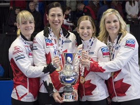 Canada lead Dawn McEwen, second Jill Officer, third Kaitlyn Lawes, skip Jennifer Jones, left to right, hold up the trophy after winning the gold medal in a final against Sweden at the World Women's Curling Championship Sunday, March 25, 2018 in North Bay, Ont.