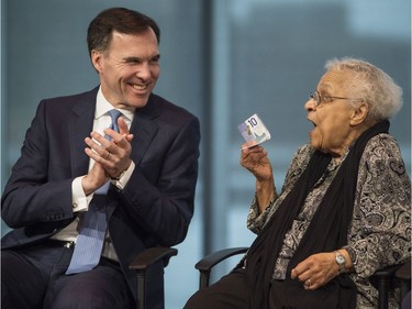 Wanda Robson, right, sister of Viola Desmond, jokes with Bill Morneau, Minister of Finance, while holding the new $10 bank note featuring Desmond during a press conference unveiling the bill in Halifax on Thursday, March 8, 2018. Desmond is the first Canadian woman to be featured on a regularly circulating bank note.